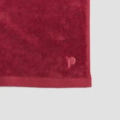 Mineral Red Organic Cotton Towels -Home Luxury Store PigletinBed BathroomCollection OrganicCottonDetail MineralRed 1 GreyBG 0b494125 29ba 4ad6 af23 1348174727f5